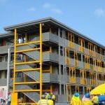 A yellow and gray modular building under construction